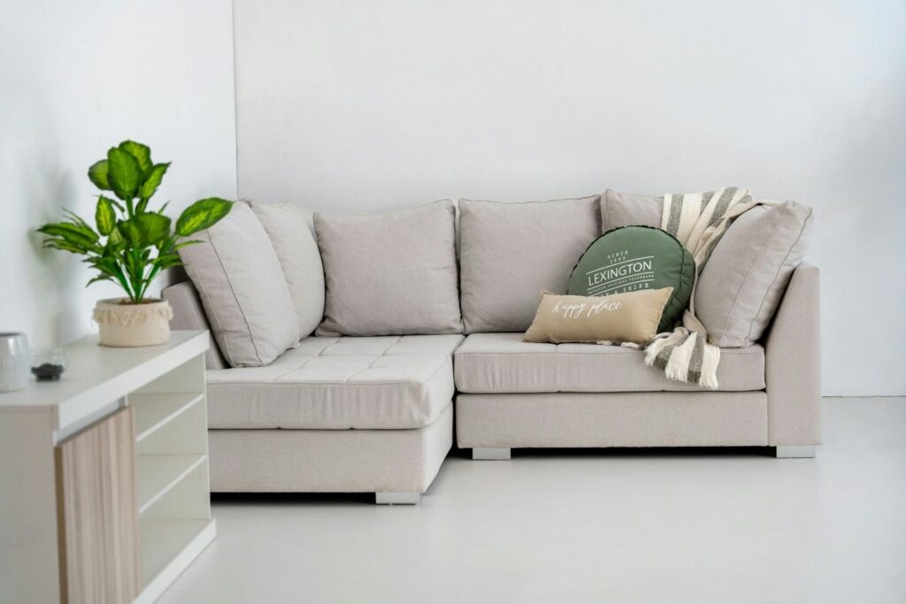 Divan sectionnel en L beige avec méridienne dans un salon lumineux